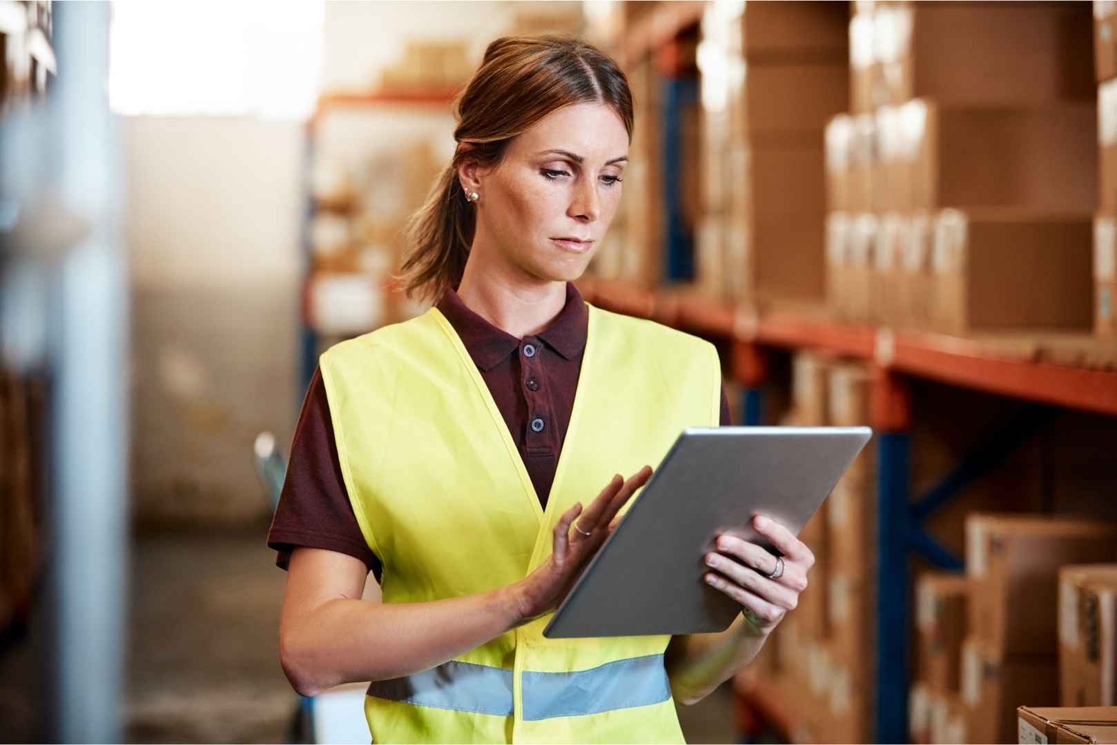 Warehouse manager checking inventories using a tablet