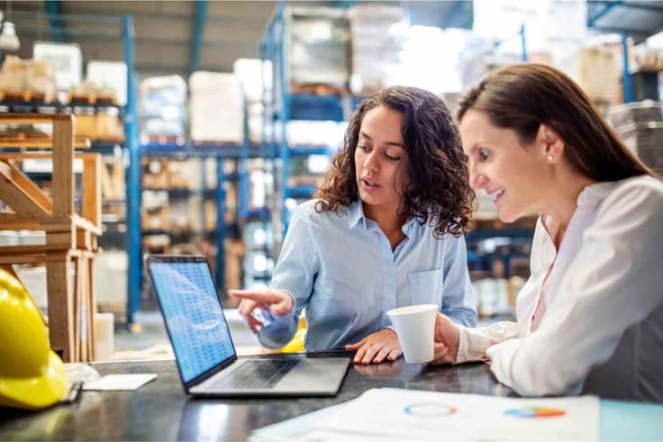 Woman showing inventory on laptop to warehouse manager-1